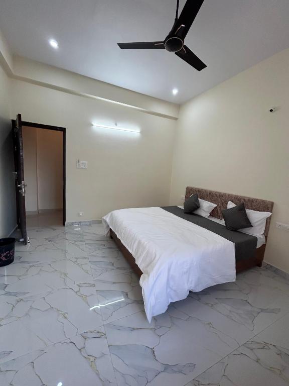 a bedroom with a bed and a ceiling fan at Hotel Pampa Sarovar in Chhatarpur