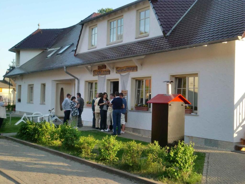 a group of people standing outside of a house at Apartments in Trebbin 26568 in Trebbin