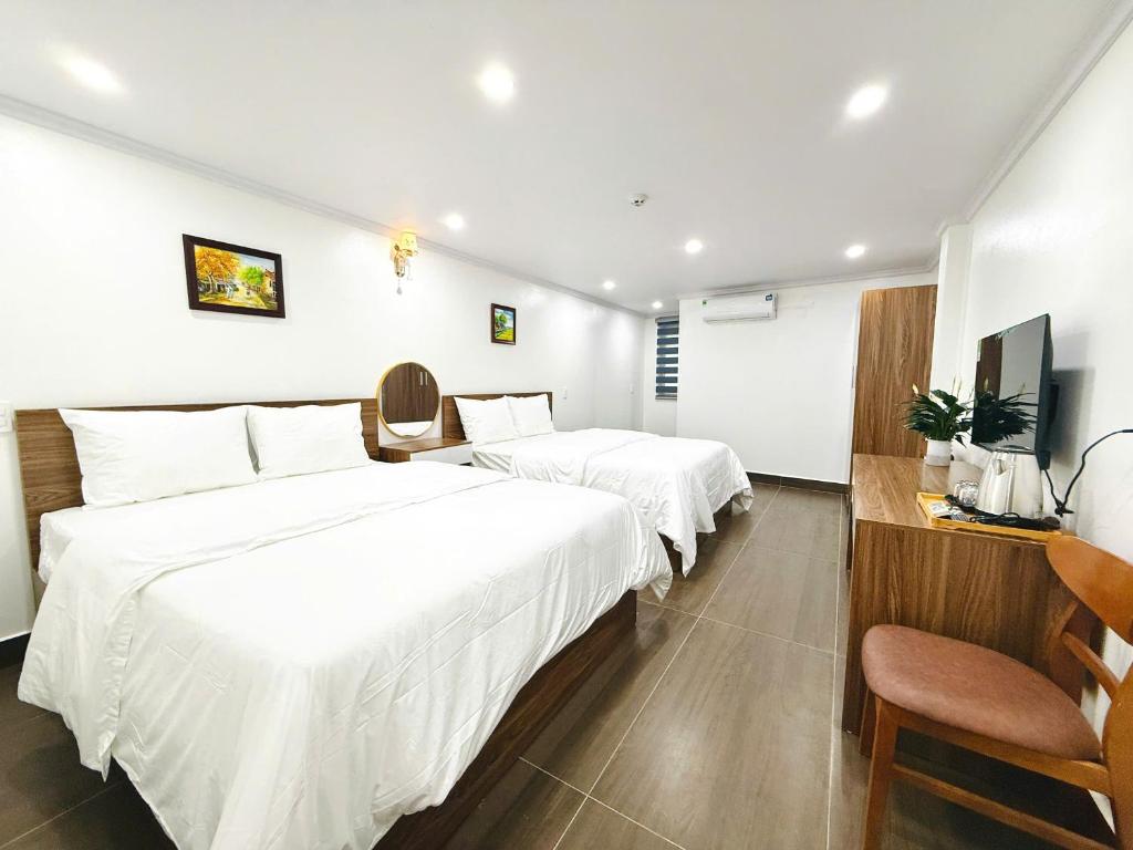 a hotel room with two beds and a television at Galaxy Airport Hotel in Hanoi