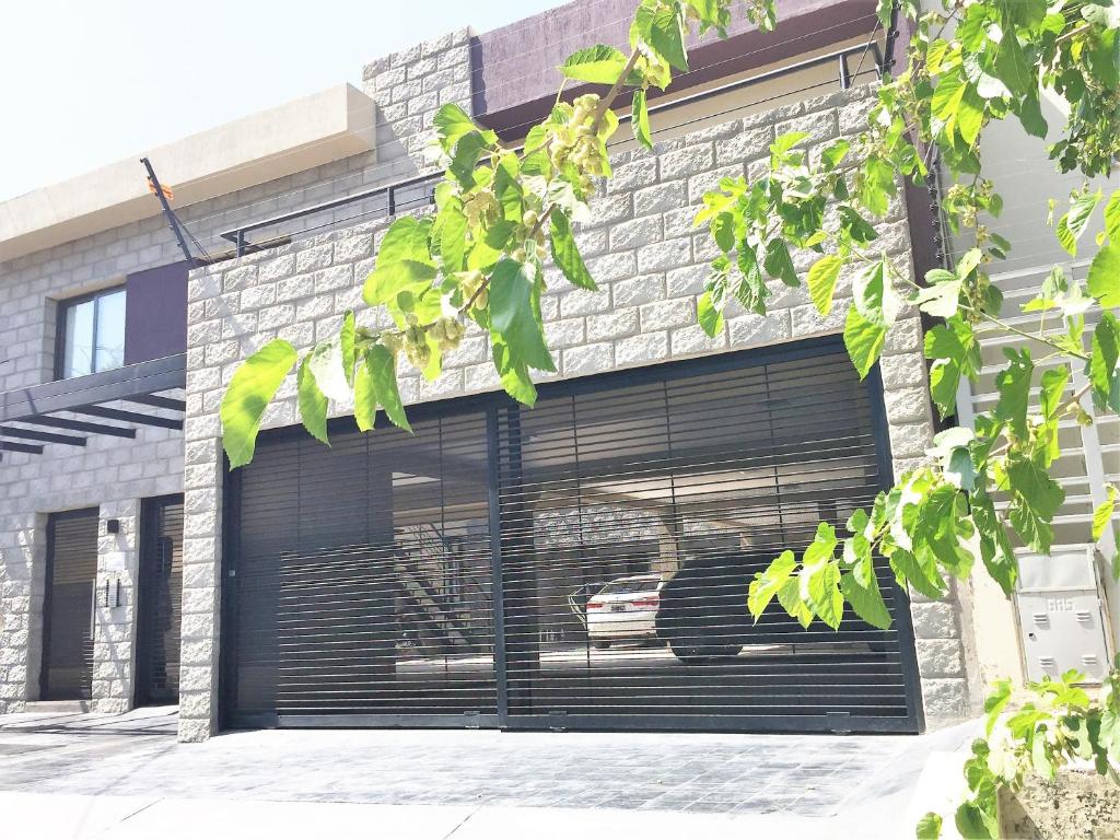 un garage avec portes noires dans un bâtiment en briques dans l'établissement Departamentos Las Cañas, à Mendoza