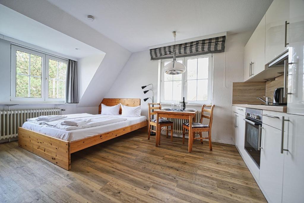 a bedroom with a bed and a table and a kitchen at Appartement-7 in Süddorf