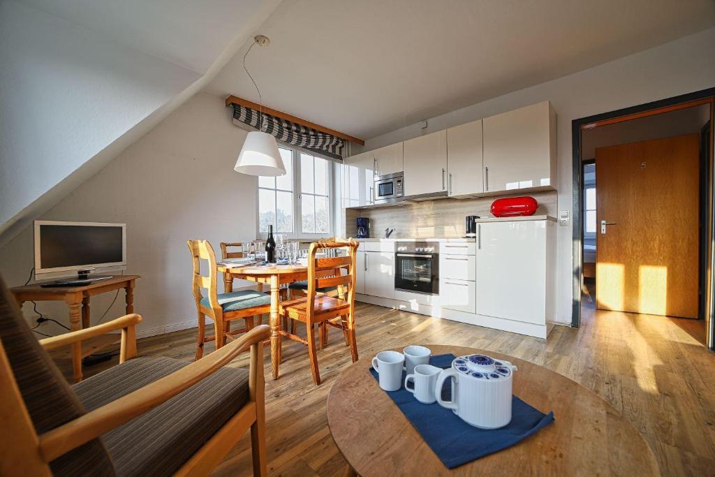 a kitchen and living room with a table and chairs at Appartement-5 in Süddorf