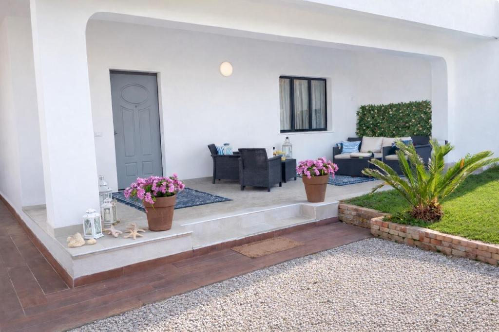 a living room with white walls and a white door at Prestige Affittacamere Paestum in Stazione di Paestum