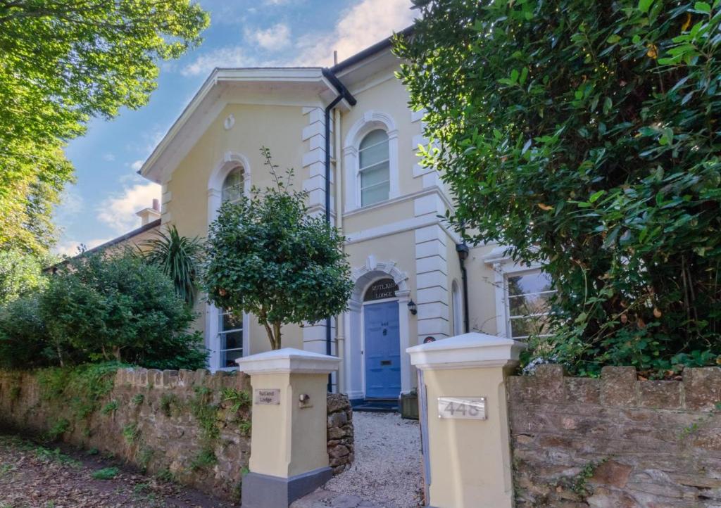 a white house with a blue door and a fence at 5 Bed in Torquay oc-rutlod in Torquay