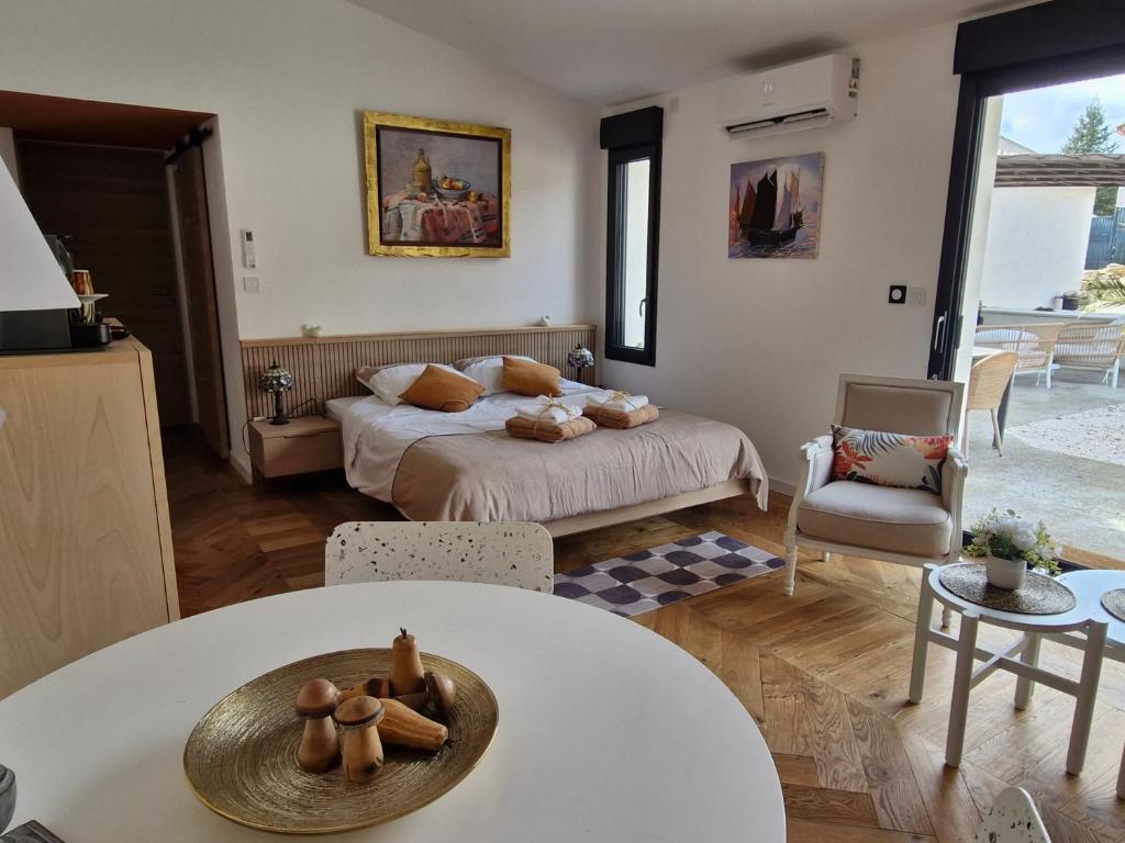 a bedroom with a bed and a table and chairs at Le cottage Bleu du Sud in Saint-Étienne-les-Orgues