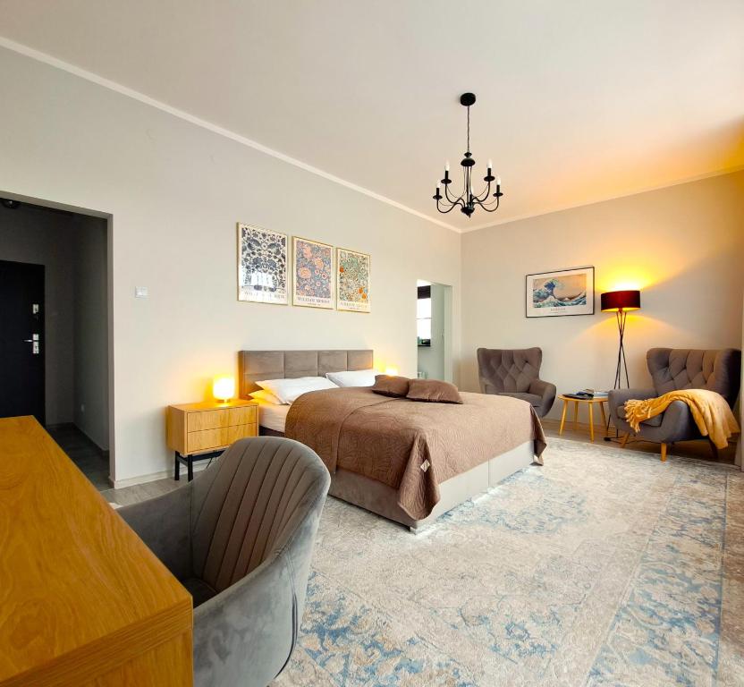 a bedroom with a bed and two chairs at Tullu Apartament - w centrum, blisko bulwaru, blisko molo in Ostróda