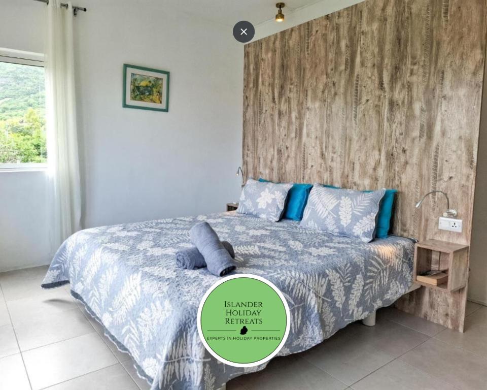 a bedroom with a bed with a wooden headboard at Studio Indian by IHR in La Gaulette