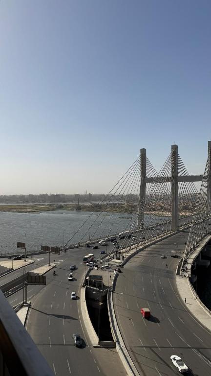 a bridge over a river with cars on a highway at Apartment on the Nile, 3 bedrooms and a living room in Cairo