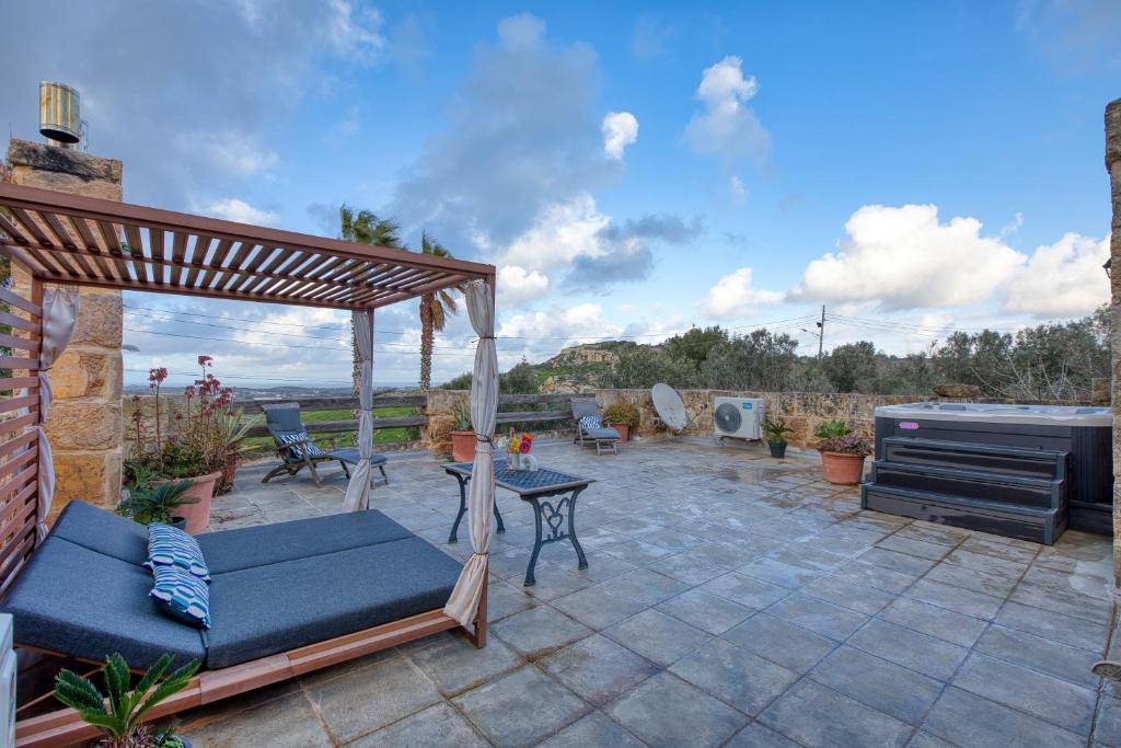 a patio with a gazebo and a grill at Stunning 2BR Villa with Pool in Mġarr