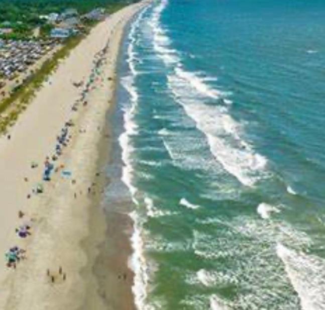 a group of people on a beach near the water at My Help Comes from The Lord Miami in Palmetto Bay