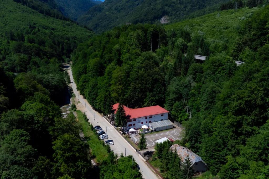 Luftaufnahme eines Berges mit einem Gebäude und einer Straße in der Unterkunft Hotel Gâlma in Moroeni