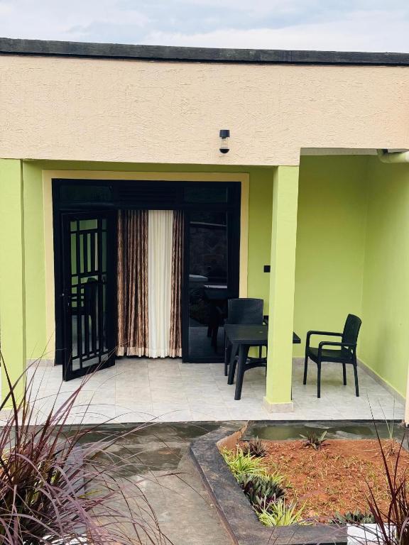 a front porch of a house with a table and chairs at Vilimani Garden Residence in Rwamagana