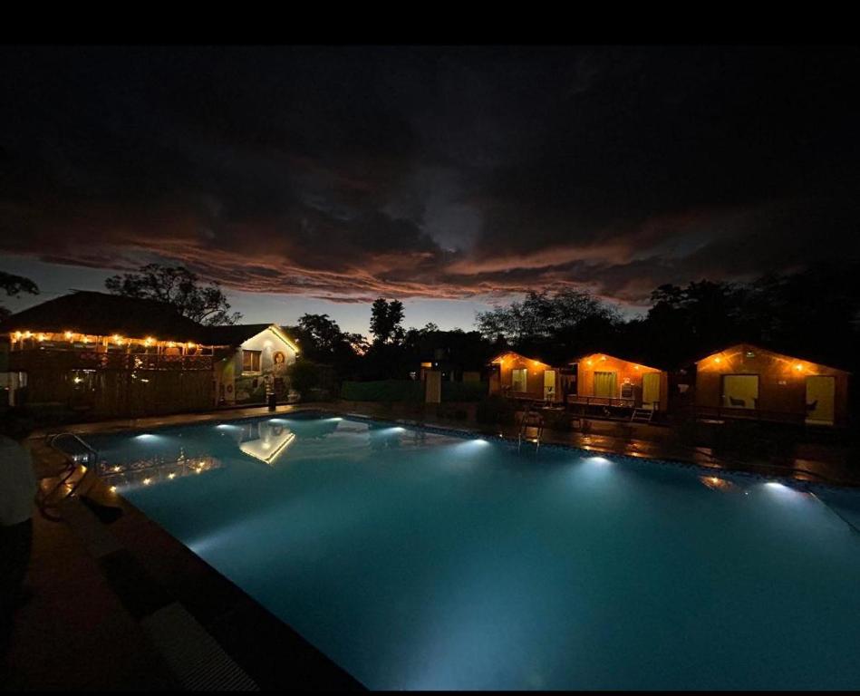 a large swimming pool at night with lights at Bamboo Life in Dera Gopipur