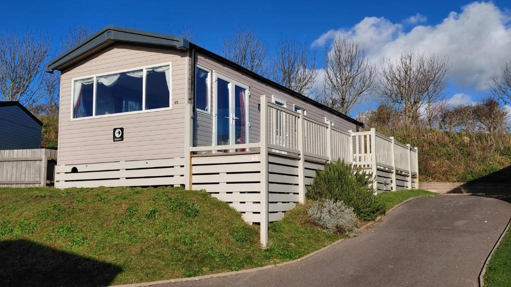 a tiny house on a hill next to a road at Driftwood at Freshwater Beach Holiday Park in Burton Bradstock
