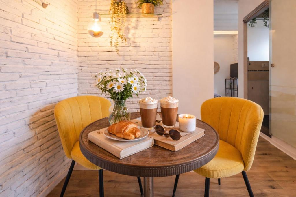 a table with bread and drinks and chairs at Little Urban Home in Trieste