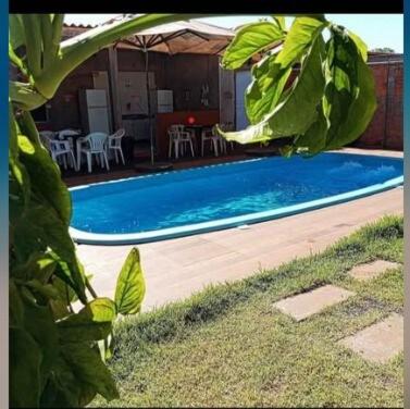 a swimming pool with chairs and a table at QUARTO CONTEINER, EDICULA ABERTA E PISCINA AQUAVibes in Cascavel