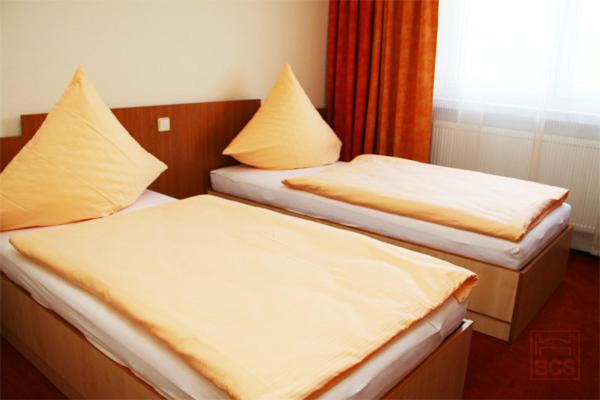 two beds sitting next to each other in a room at Pension Augsburg Ost in Augsburg