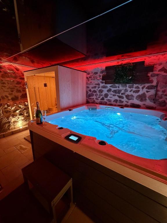 a large hot tub in a room with red lights at Les Murmures du Rhône - Appartement Cosy et Lumineux in Andance