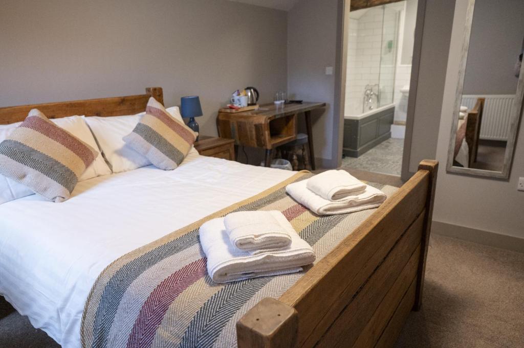 a bedroom with a bed with towels on it at The Milestone in Sowerby Bridge