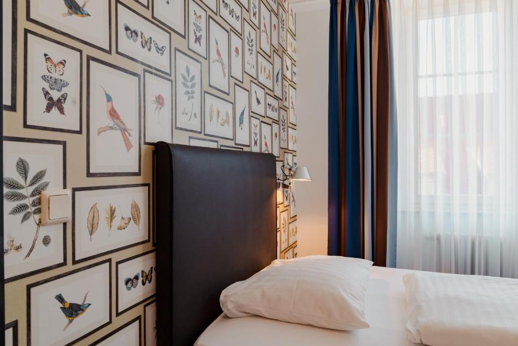 a bedroom with a bed and a wall of pictures at Hotel & Gasthaus Backmulde in Heidelberg