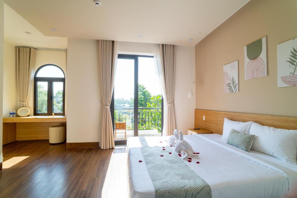 a bedroom with a large white bed with a child on it at Villa Layna's home in An Bàn (2)