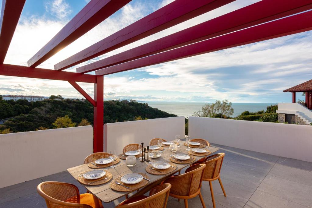 a dining table on the balcony of a house at SUNSET Keyweek Villa ocean view and private pool in Bidart