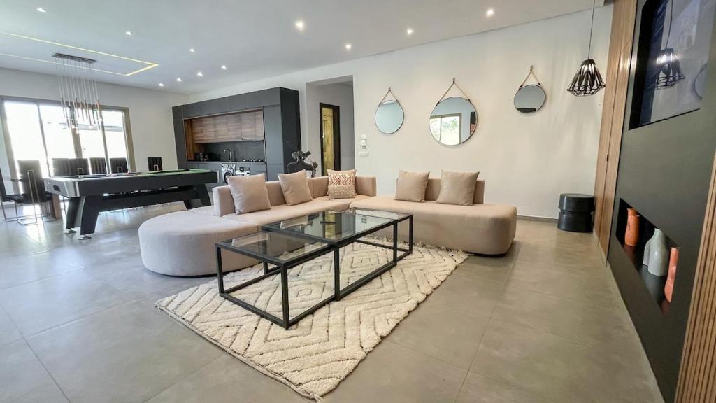 a living room with a couch and a glass table at Beautiful Asma Villa with pool in Marrakesh