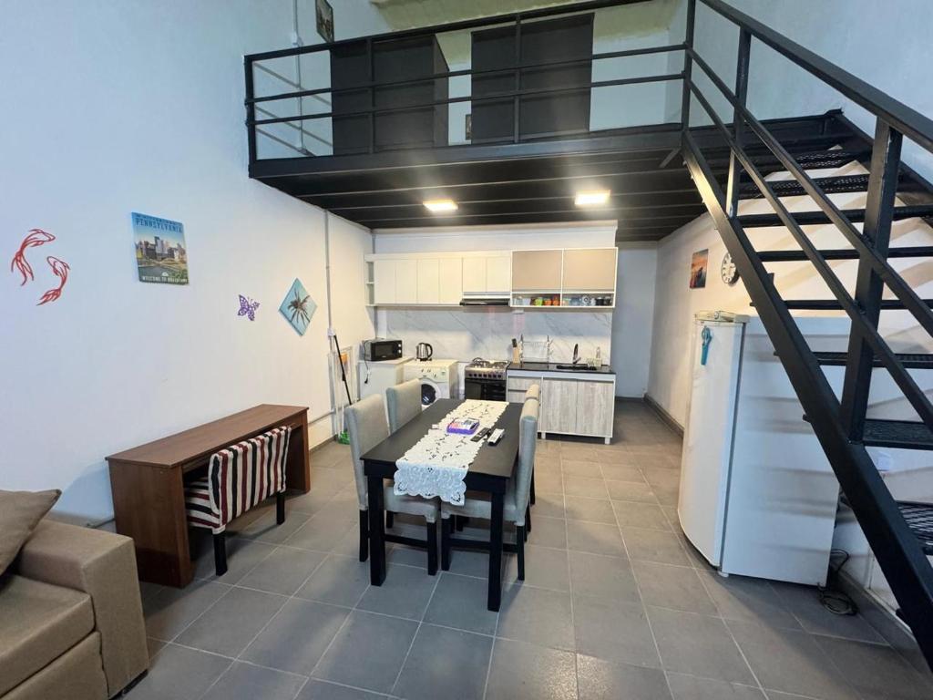 a kitchen and living room with a spiral staircase at Loft Neuquén in Neuquén