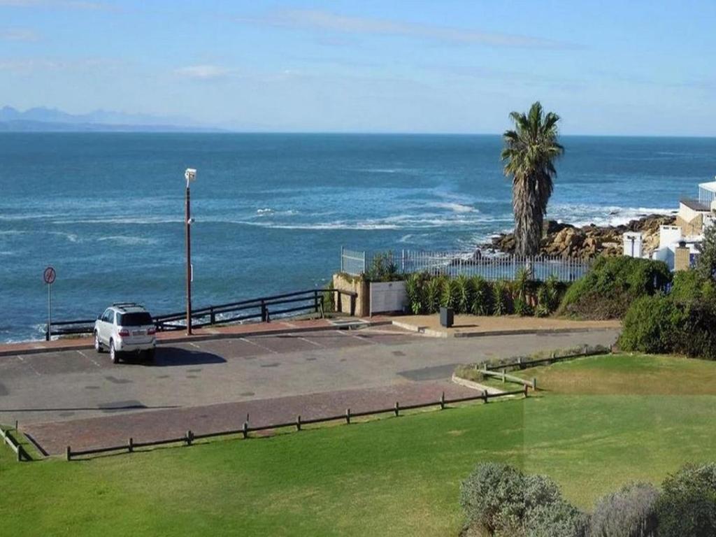 a white van parked in a parking lot next to the ocean at King Fisher 6 in Mossel Bay