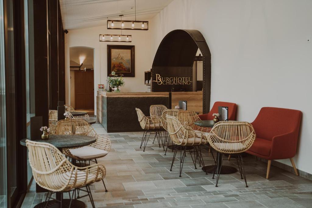 a restaurant with tables and chairs and a counter at Burghotel Schlaining in Stadtschlaining