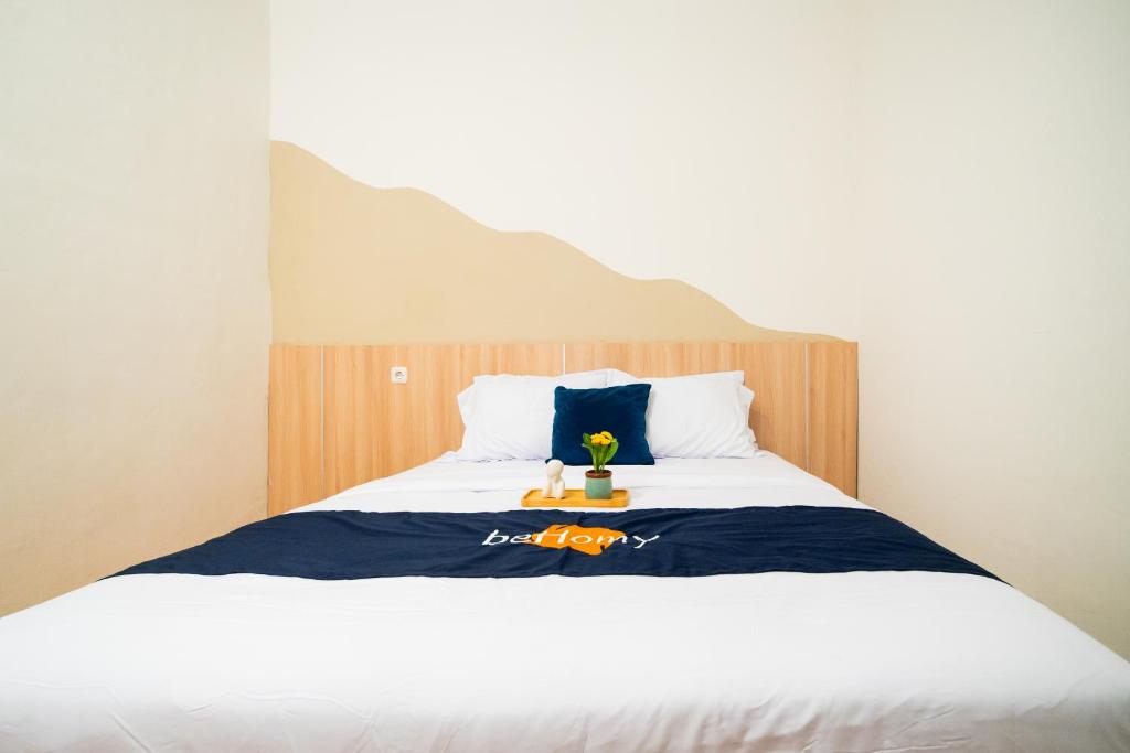 a bedroom with a bed with a blue and white blanket at Behomy Urban Point Karawang in Karawang