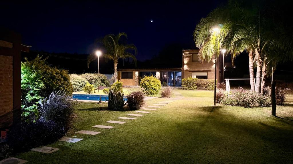 a yard with a house and a swimming pool at night at Casa Ruta 1 in San José