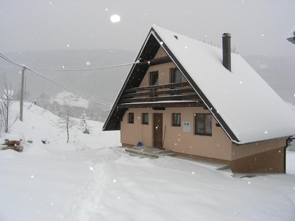una casa con nieve en el techo en Planinska kuća Kupres en Kupres