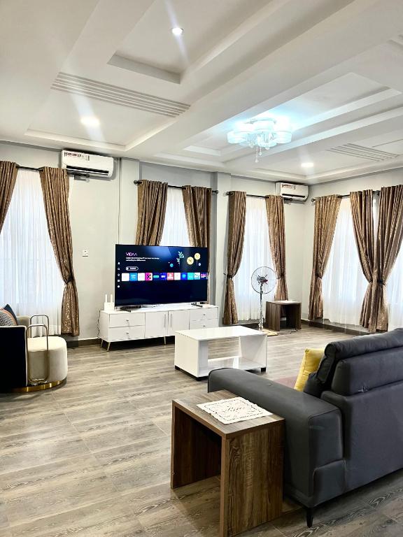 a living room with a couch and a tv at Lux-Home Enugu in Enugu