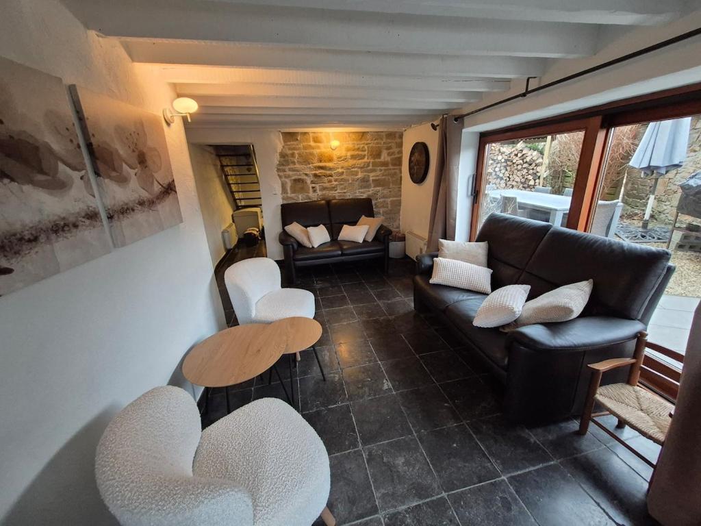 a living room with a couch and a table and chairs at Le pas de la Fagne in Sprimont