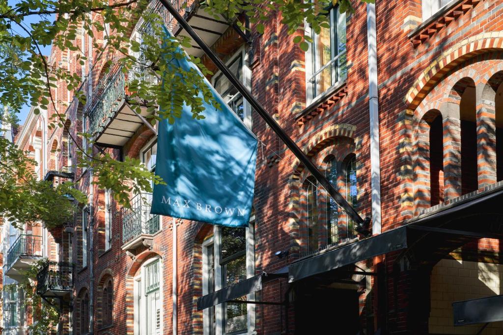 a blue flag hanging from the side of a brick building at Max Brown Hotel Museum Square, part of Sircle Collection in Amsterdam