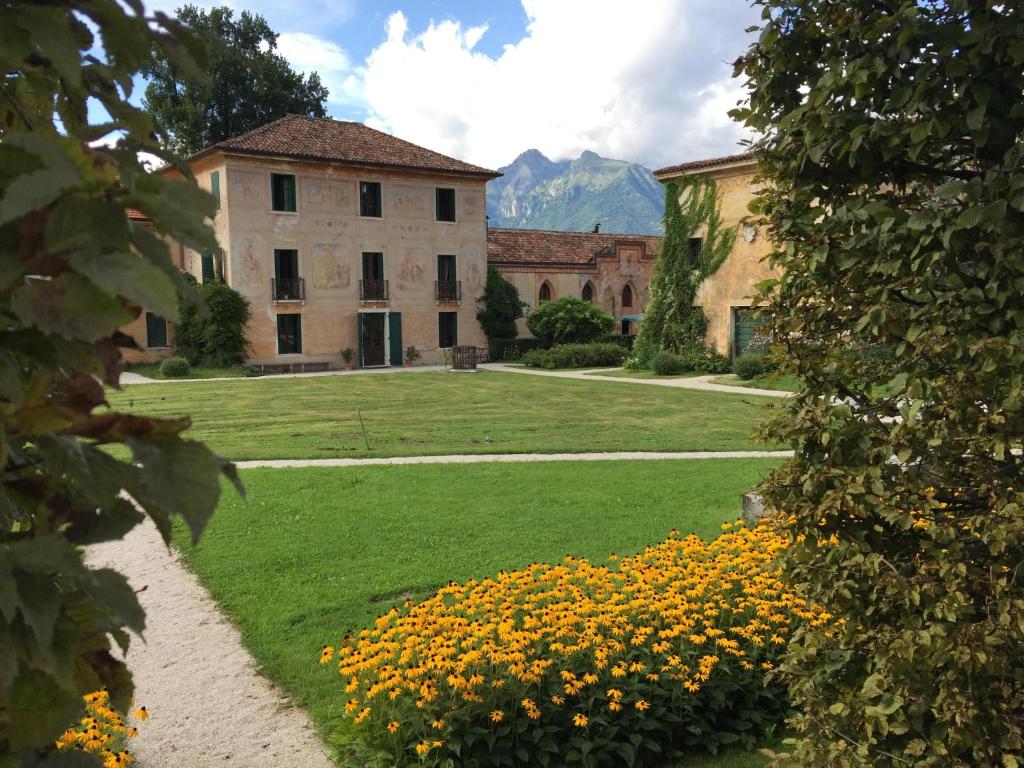 a garden with yellow flowers in front of a building at Bed & Breakfast Villa Buzzati in Belluno