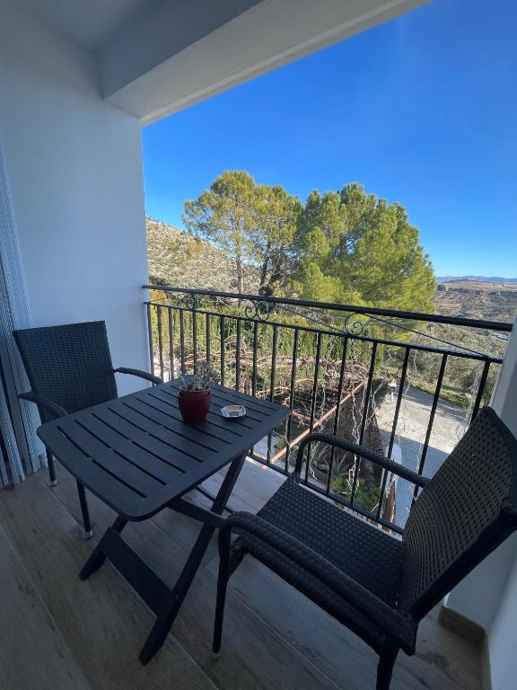 a table and chairs on a balcony with a view at El Olivar de la Solana in Castril