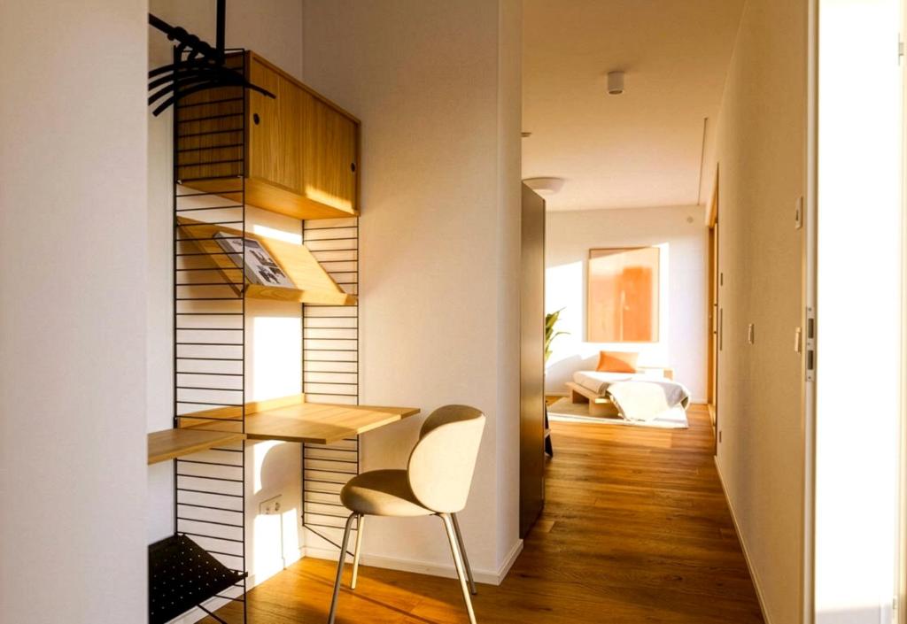 a small apartment with a staircase and a chair in a room at TrulySpace - Modernes Apartment am Rathausplatz, Terrasse, Fahrstuhl in Augsburg