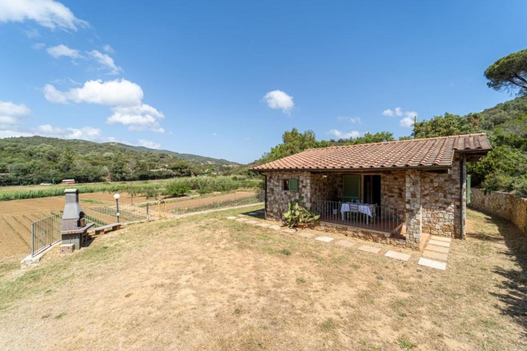a small stone house on top of a hill at Apartments La Tenuta where the sea meets the land - Goelba in Porto Azzurro