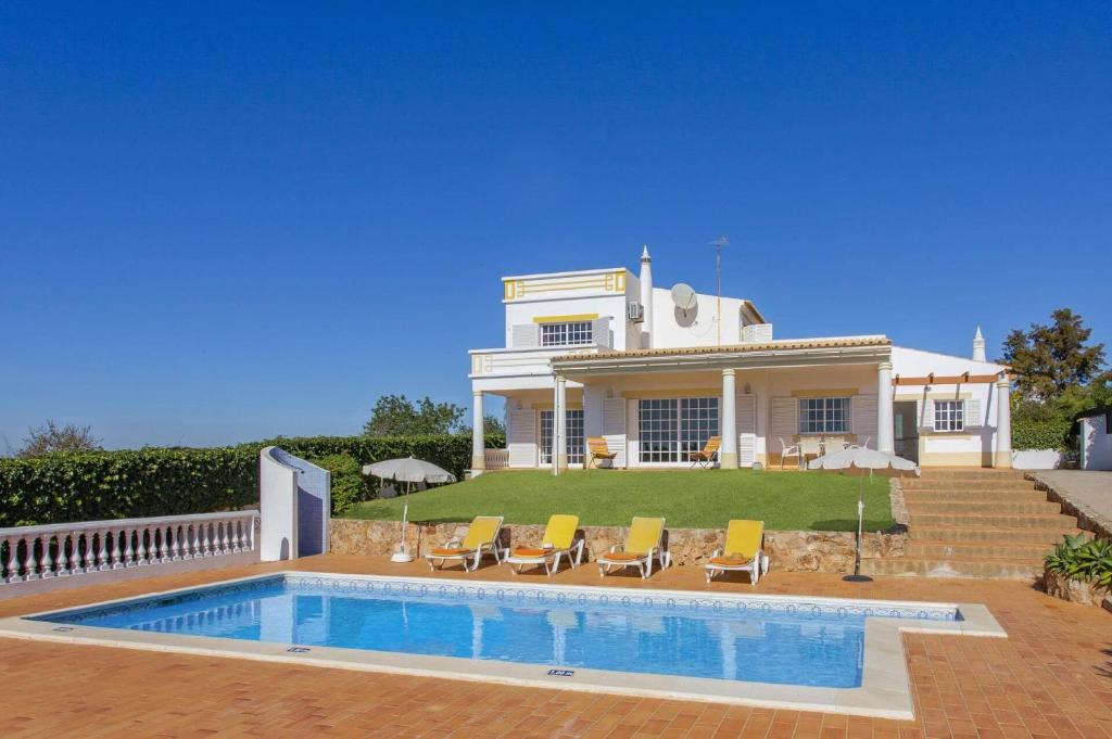 a house with a swimming pool in front of it at Villa Colina do Sol by Villa Plus in Paderne