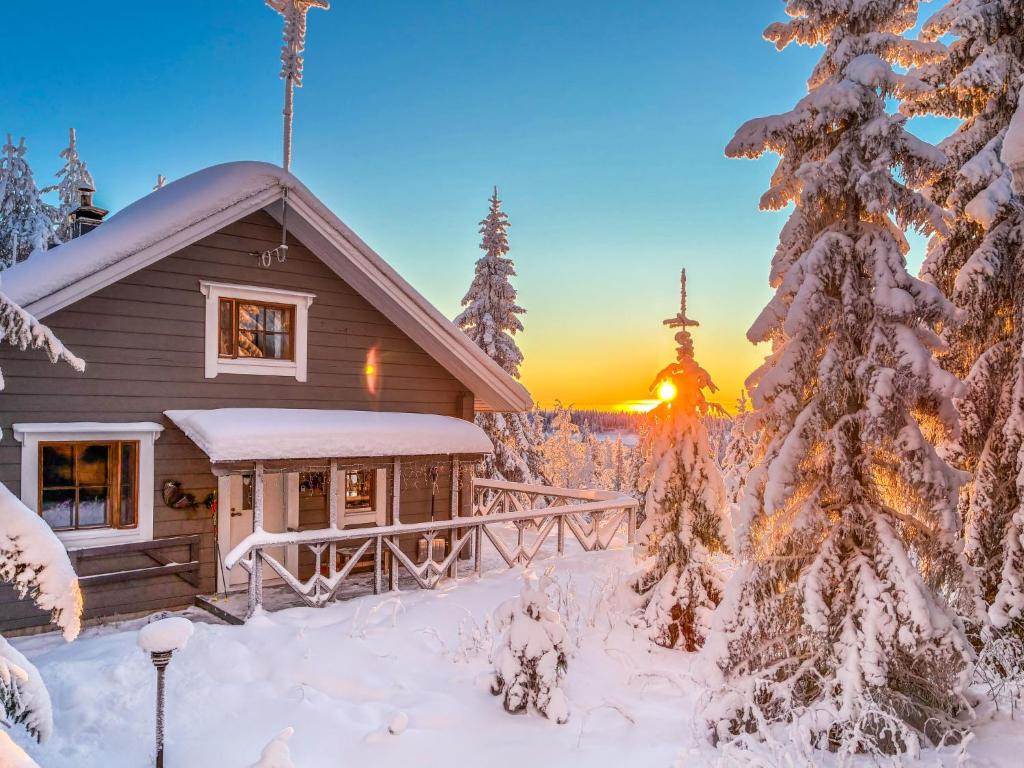 a cabin in the snow with the sunset in the background at Holiday Home Joutsen a by Interhome in Ruka