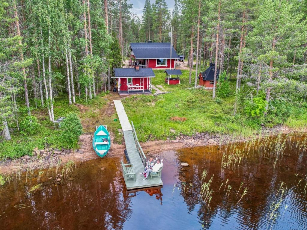 a boat on a dock in front of a house at Holiday Home Piilola by Interhome in Raanujärvi