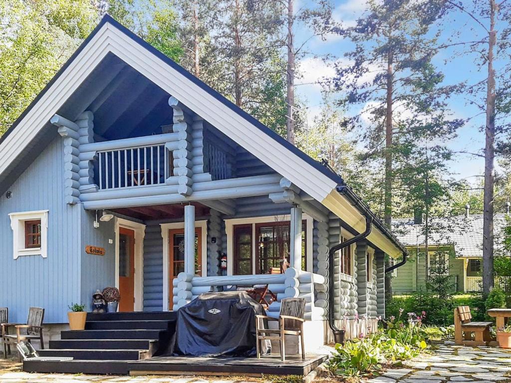 a small blue house with a porch and stairs at Holiday Home Eskola by Interhome in Lahdenperä