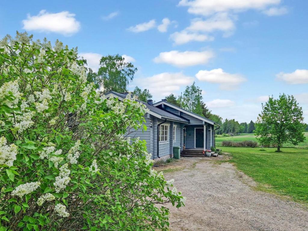 a small blue house with a gravel driveway at Holiday Home Annas beach by Interhome in Haminankylä