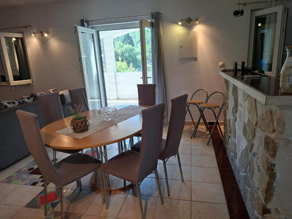 a dining room with a wooden table and chairs at Apartman MAKA in Kučiće