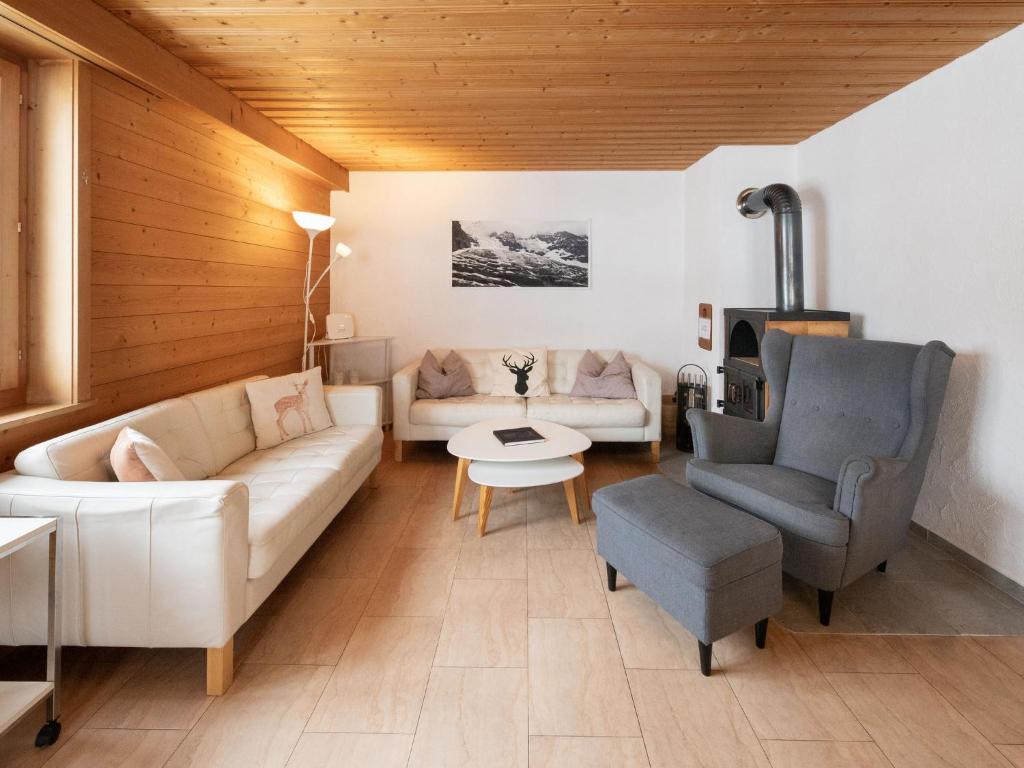 a living room with a couch and two chairs at Holiday Home Chalet Reinhysi by Interhome in Grindelwald