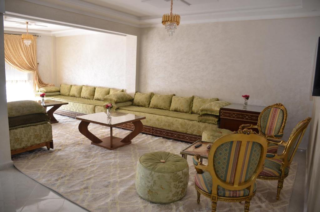 a living room with a couch and tables and chairs at Appartement Laaz in Midelt