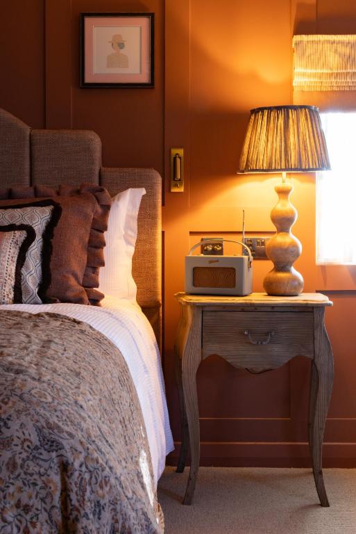 a bedroom with a bed and a table with a lamp at The George and Dragon - A Heartwood Inn in Marlow
