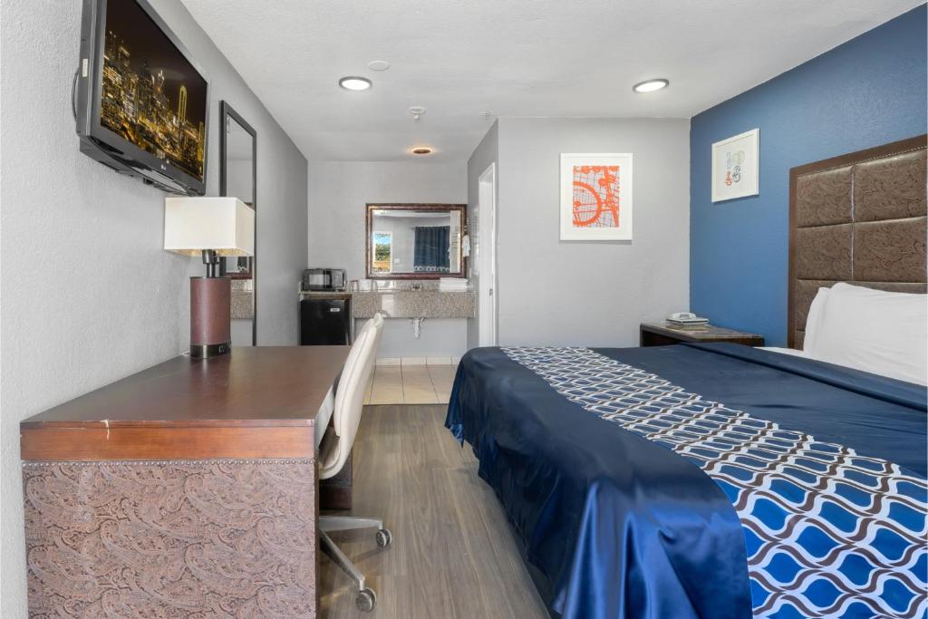 a hotel room with a bed and a desk at Golden Inn Dallas by Hotel O in Dallas